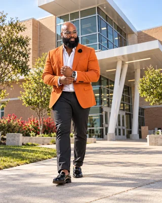 Dr. Sully walking outdoors in an orange jacket